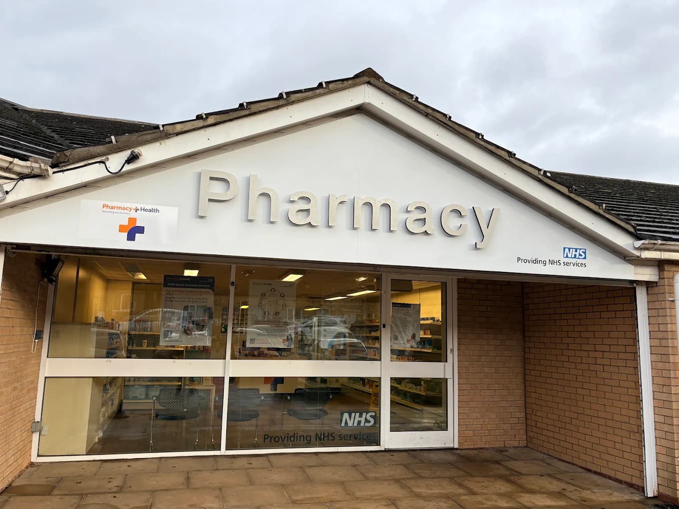 The front of Rockwell Pharmacy on Summerfield Road, Thorpe Edge, with its glass entrance and NHS sign